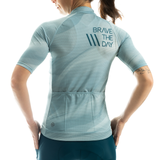 Light blue athletic shirt with 'Brave The Day' text on the back, worn by a person.